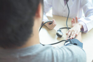 doctor-checking-patient-arterial-blood-pressure(Hypertension)